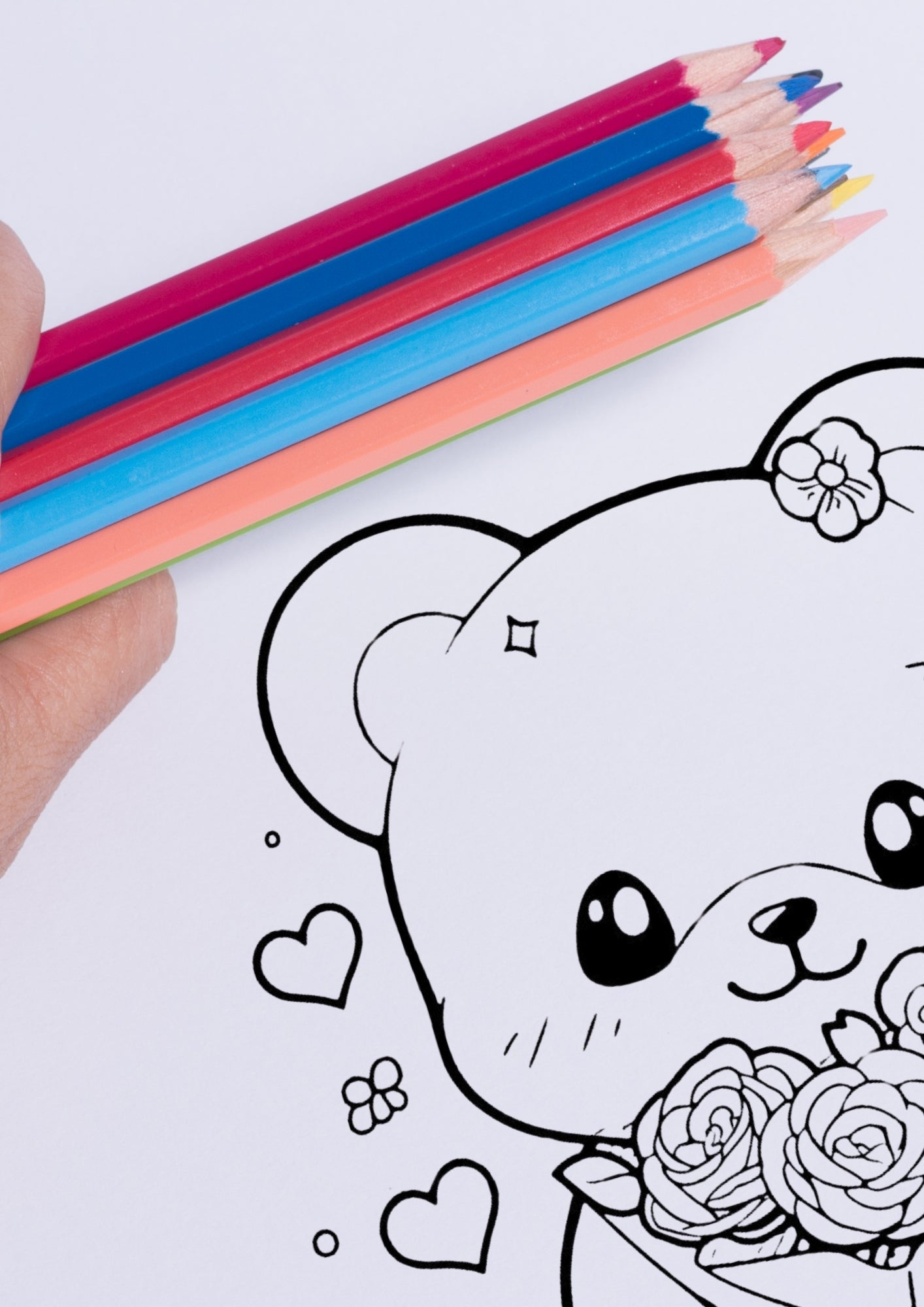 Nærbilde av fargeleggingsside med en søt bamse med blomst bak øret og roser, vist med fargeblyanter i rosa, blå og oransje toner