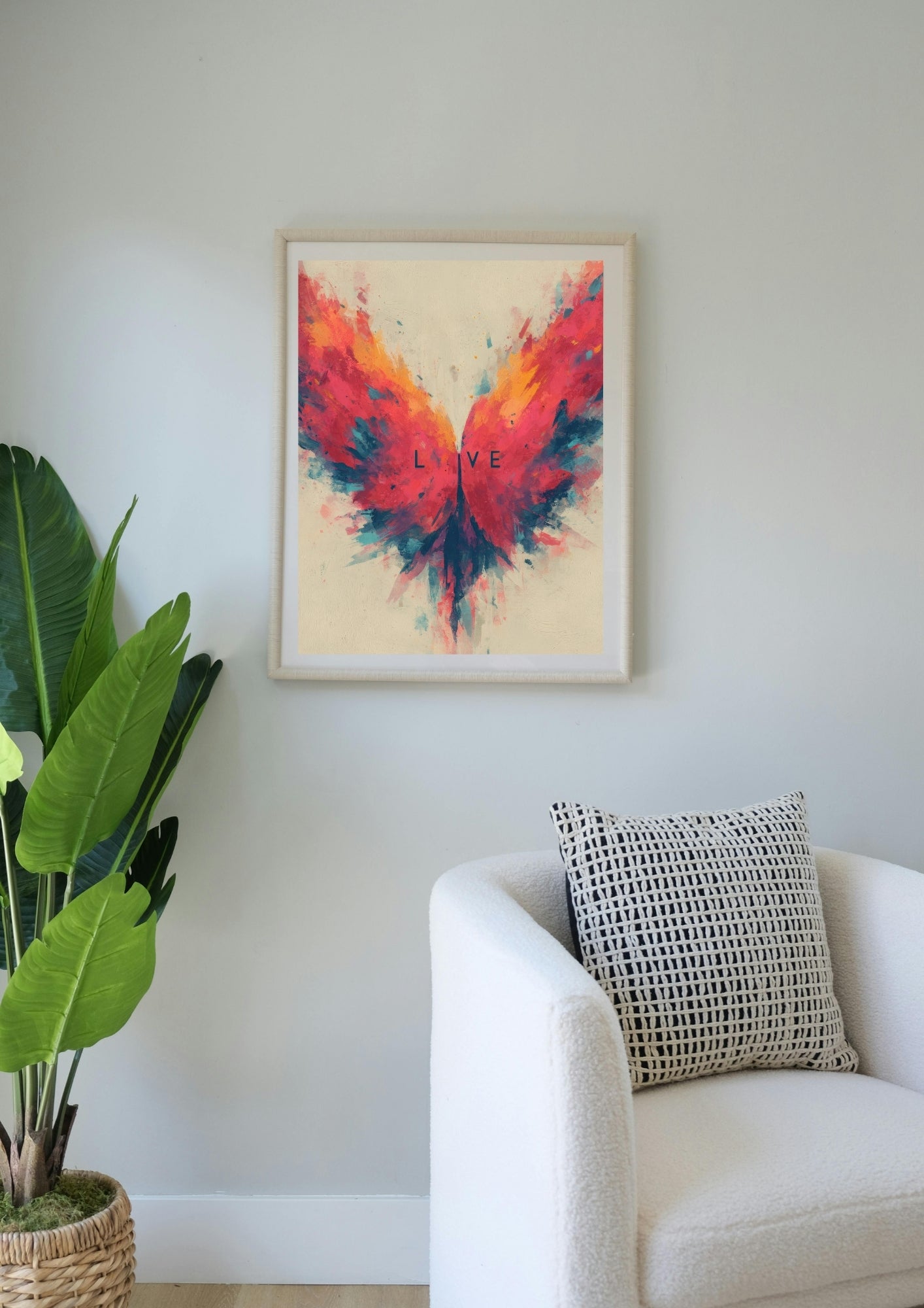 Fargerik LOVE-sommerfuglplakat i hvit ramme ved lenestol og grønn plante – ekspressiv abstrakt veggkunst – digital utskrift fra LilleStjerne